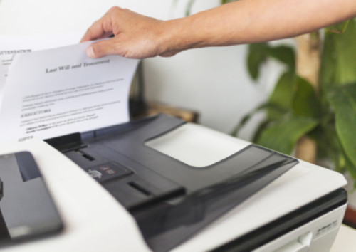 Image of a person putting paper into a printer
