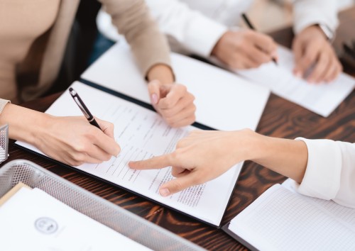 Image of a signing a Will with two other people watching